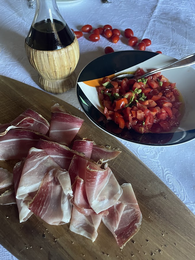 Prosciutto Toscano on a wodden board and bruschetta with fresh tomatoes